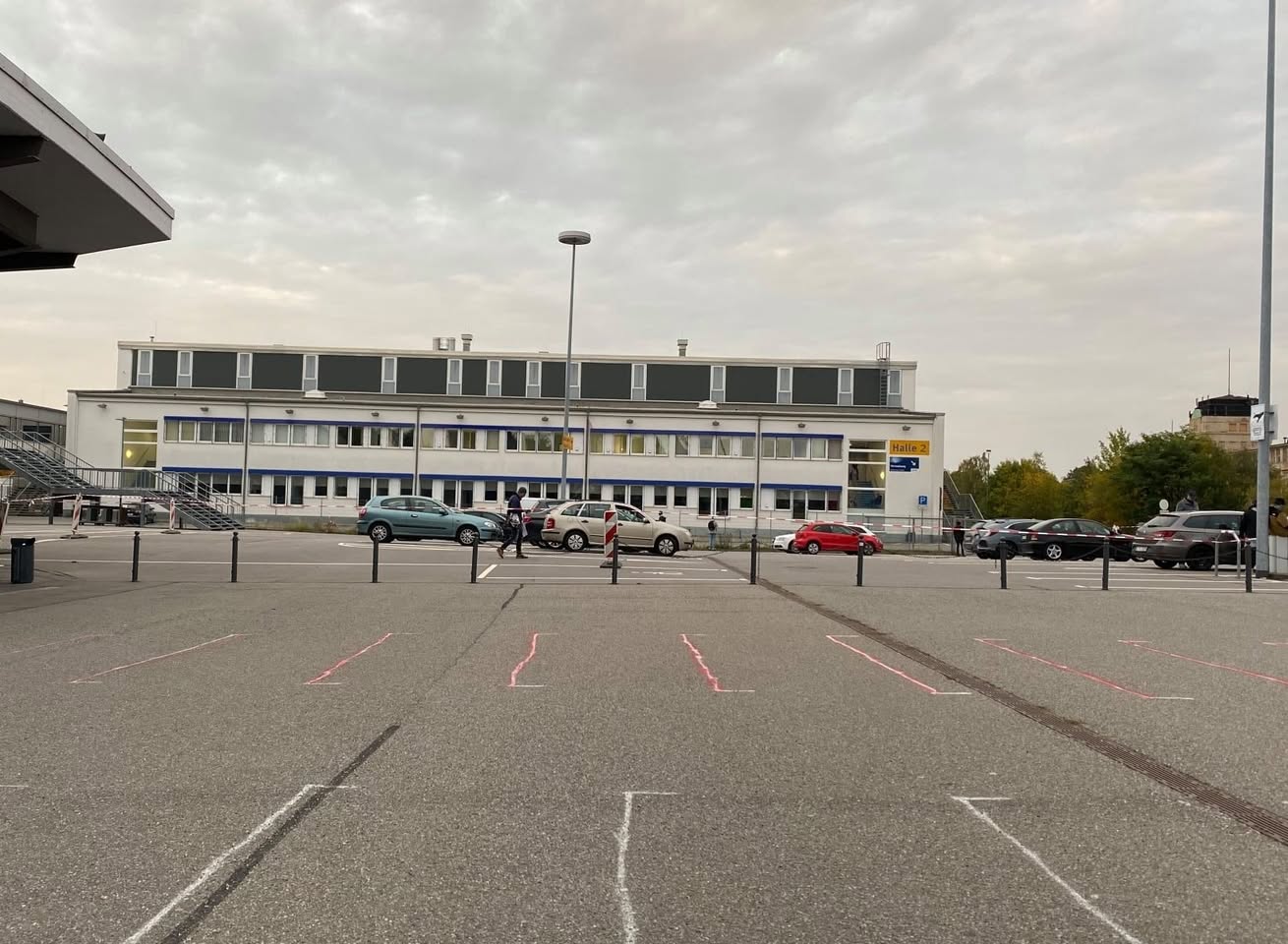 Menschen werden auf dem Parkplatz in verschiedenfarbige Bereiche eingeteilt, während diese dann im Treppenhaus vermischt werden.